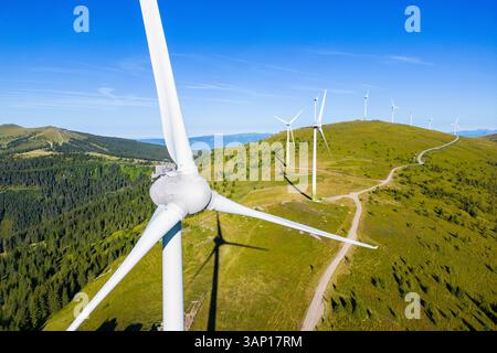 Vue aérienne des éoliennes sur une crête de montagne pittoresque avec un ciel dégagé, Weinebene, Autriche. Banque D'Images