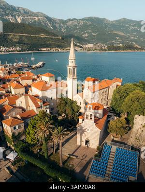 Vue aérienne du magnifique paysage urbain avec l'église de la Sainte Trinité et les toits rouges au bord de la mer Adriatique, Budva, Monténégro. Banque D'Images