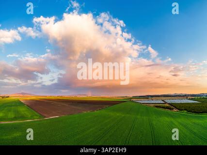 Vue aérienne d'un arc-en-ciel dans un champ avec des nuages de pluie, vallée de Jezreel, district nord, Israël. Banque D'Images