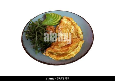 Omelette fraîche et savoureuse avec salade verte roquette, tranches de saumon fumé, avocat coupé en morceaux sur une image isolée plaquée tendance, gros plan sélectif, découpe avec chemin de coupe objet repas du matin Banque D'Images