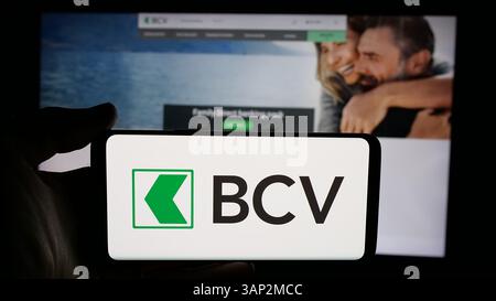 Stuttgart, Allemagne - 12-04-2024 : personne tenant un téléphone portable avec le logo de la société suisse Banque Cantonale Vaudoise (BCV) sur l'écran Banque D'Images