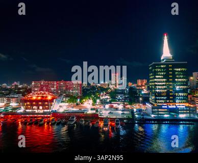 Vue aérienne d'un paysage urbain dynamique avec gratte-ciel illuminé et front de mer, Lagos, Nigeria. Banque D'Images