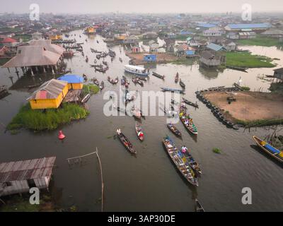 Vue aérienne de bateaux dans un village africain traditionnel sur un lac tranquille aux maisons colorées, Assokome, Atlantique, Bénin. Banque D'Images