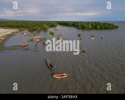 Vue aérienne de la plage sereine de la mer de Dhumkhali au coucher du soleil avec des vagues douces et des bateaux, Chittagong, Bangladesh. Banque D'Images