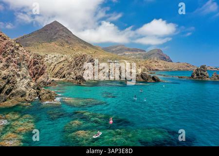 Vue aérienne des gens paddle board le long de la côte de Cabo de Gata zone volcanique rocheuse avec ses eaux turquoise claires de Almería, Andalousie, Banque D'Images