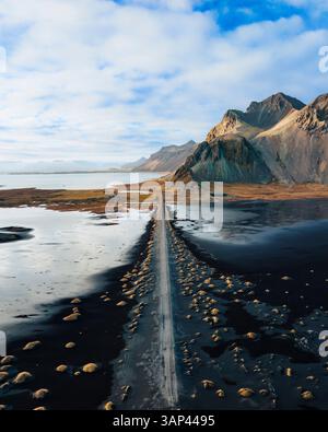 Vue aérienne par drone de la montagne Vestrahorn avec une route menant vers elle, coucher de soleil sur l'est de l'Islande. Banque D'Images