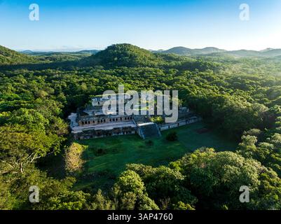 Vue aérienne des ruines antiques au milieu de la jungle luxuriante et des collines, Oxkutzcab, Yucatan, Mexique. Banque D'Images