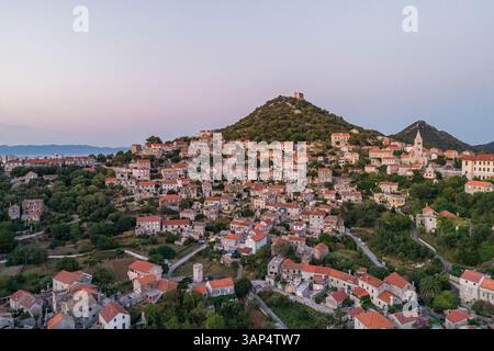 Vue aérienne panoramique de Lastovo, une petite ville au sommet d'une colline près de la côte, province de Dubrovnik, Croatie. Banque D'Images