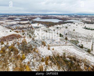 Vue aérienne du paysage d'automne serein avec la première neige couvrant des arbres colorés, Parc National de Groote Peel, Asten, pays-Bas. Banque D'Images