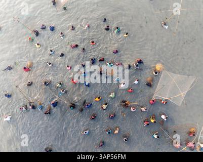 Vue aérienne d'un festival d'hiver coloré sur un lac avec des bateaux traditionnels en bois et un rassemblement de gens, Rajshahi Division, Bangladesh. Banque D'Images