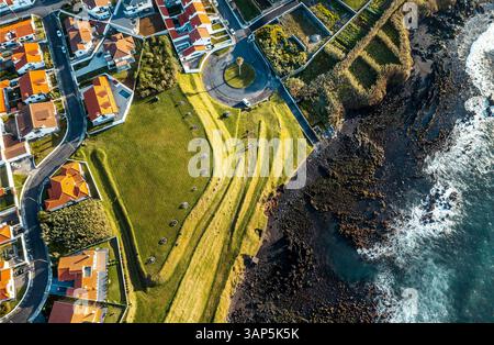 Vue aérienne des maisons résidentielles le long de la côte à Vila Franco do Compa et le littoral, Sao Miguel, Açores, Portugal. Banque D'Images