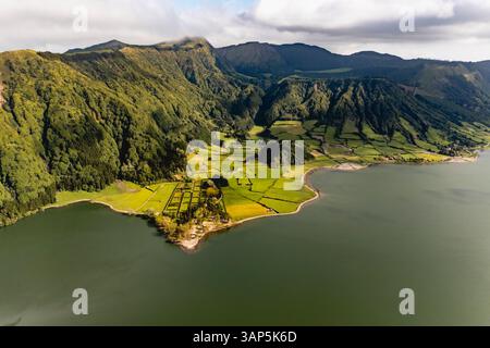 Vue aérienne des champs cultivés le long de la côte du lac Lagoa Verde, Sete Cidades, Açores, Portugal. Banque D'Images