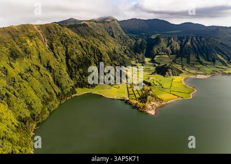 Vue aérienne des champs cultivés le long de la côte du lac Lagoa Verde, Sete Cidades, Açores, Portugal. Banque D'Images