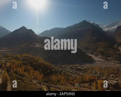 Vue aérienne du village isolé entouré de montagnes majestueuses et d'arbres colorés en automne, Hunza, cônes passu, vallée de Gojal, Gilgit-Baltistan, Pakis Banque D'Images