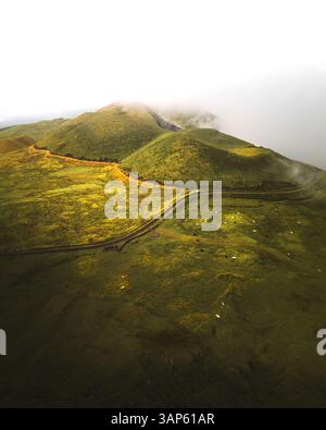 Vue aérienne d'une petite route conduisant près de deux cratères volcans sur l'île de Pico, archipel des Açores, Portugal. Banque D'Images