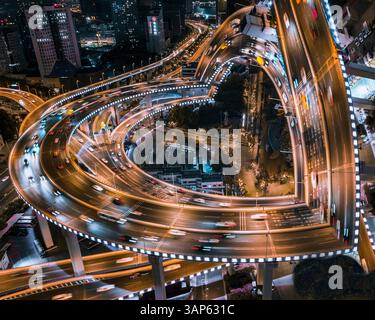 Vue aérienne d'une rue de jonction animée avec intersection complexe la nuit dans le centre-ville de Shanghai, Chine. Banque D'Images