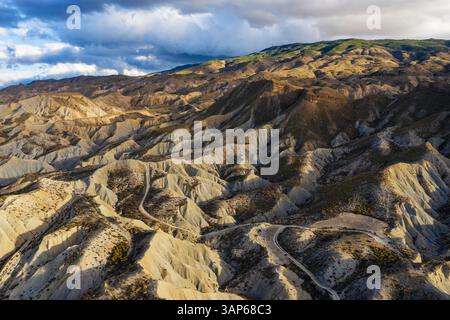 Vue aérienne du vaste et aride désert de Tabernas avec des montagnes escarpées et des collines sous un ciel pittoresque, Tabernas, provincia de Almeria, Espagne. Banque D'Images