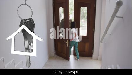 Image de clés sur une femme caucasienne et sa fille portant des masques ouvrant la porte Banque D'Images