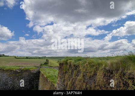 Champs verts vus des murs de pierre du fort Charles sur le port de Kinsale dans le comté de Cork, Irlande, sous un ciel bleu partiellement nuageux. Banque D'Images