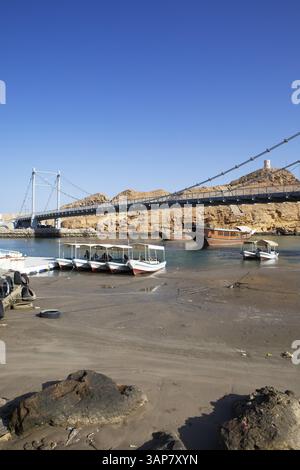 Pont suspendu Al-Ayja sur le golfe d'Oman, dhows et bateaux d'excursion dans l'eau en face, province de Janub ash-Sharqiyya, Oman, Asie Banque D'Images