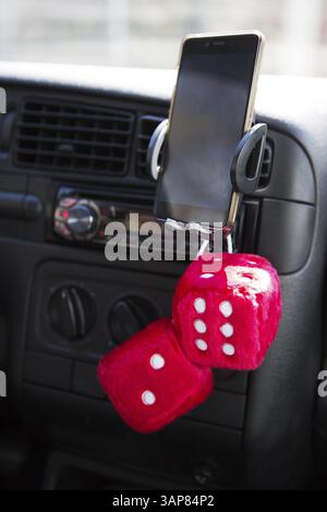 Cubes rouges sur le support de téléphone portable d'une voiture Banque D'Images