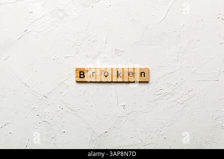 Mot CASSÉ écrit sur le bloc de bois. TEXTE CASSÉ sur la table de ciment pour votre conception, concept. Banque D'Images