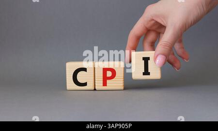 IPC - symbole de l'indice des prix à la consommation. Mot concept CPI sur cubes en bois. Main d'homme d'affaires. Beau fond gris. Business and CPI concept. Copier l'espace Banque D'Images