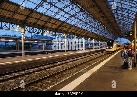 Lourdes (sud-ouest de la France) : TGV Inouï arrivant à la gare et passagers sur le quai pour le premier trajet matinal Banque D'Images