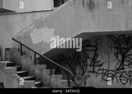Image en noir et blanc d'escaliers qui montent d'un garage de stationnement dans le centre de Targu Mures, Roumanie. Le graffiti est écrit sur les murs. Banque D'Images