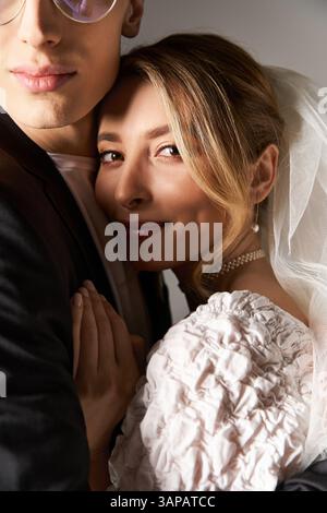 Un couple ravi partage un moment tendre, habillé élégamment pour leur cérémonie de mariage printanière. Banque D'Images