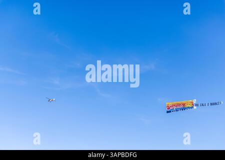 petit avion monomoteur tirant une bannière colorée pour le thé glacé surfside Banque D'Images