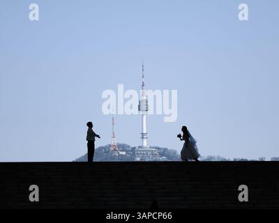 Une silhouette romantique d'une mariée et mariée avec l'emblématique Tour Namsan (N Seoul) de Séoul en arrière-plan, symbolisant l'amour et l'engagement dans le cœur Banque D'Images