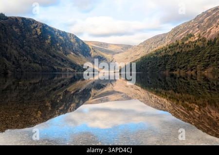 Lac reflétant les pentes de montagne à Glendalough, la beauté tranquille d'une célèbre vallée irlandaise historique. Banque D'Images