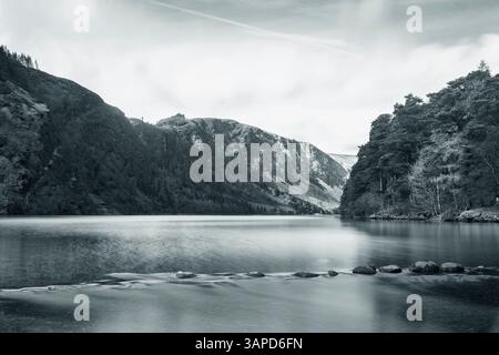 Lac reflétant les pentes de montagne à Glendalough, la beauté tranquille d'une célèbre vallée irlandaise historique. Banque D'Images