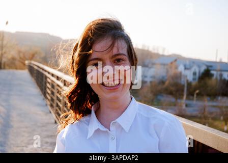 Femme souriant par une journée ensoleillée à l'extérieur. Banque D'Images