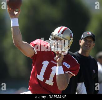 16 août 2011 - Santa Clara, CA, États-Unis - Jim Harbaugh, entraîneur-chef des 49ers de San Francisco, à droite, regarde le quarterback Alex Smith (11 ans) lancer pendant le camp d'entraînement au centre d'entraînement des 49ers à Santa Clara, Californie, le mardi 16 août 2011. (Crédit image : © Nhat V. Meyer/San Jose Mercury News/MCT/ZUMAPRESS.com) Banque D'Images