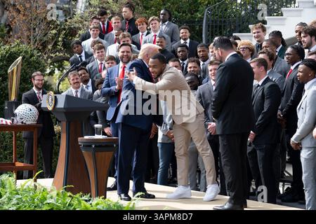 Washington, États-Unis. 14 avril 2025. U. Le président Donald Trump, à gauche, est embrassé par les Buckeyes Running back TreVeyon Henderson, au centre, lors d'un événement célébrant le 2025 College Football National Champion Ohio State University Buckeyes, au Portico sud de la Maison Blanche, le 14 avril 2025, à Washington, DC crédit : Joyce Boghosian/White House photo/Alamy Live News Banque D'Images