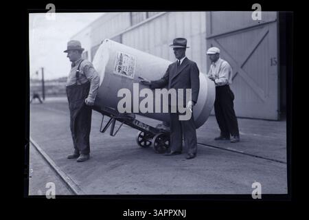 Photographie des bibliothèques de l'Université de l'Oregon représentant trois hommes roulant un grand tambour, faisant partie de la collection de nitrate. Banque D'Images
