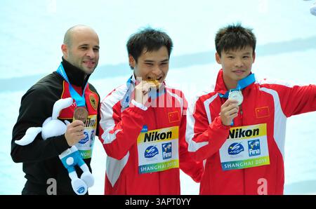18 juil. 2011 ; Shanghai, CHINE ; le médaillé d'or Li Shixin (C) de Chine pose avec son coéquipier et médaillé d'argent He min (R) et le médaillé de bronze Pavlo Rozenberg d'Allemagne après la finale de tremplin de 1 m masculin au troisième jour des 14e Championnats du monde FINA à l'Oriental Sports Center. (Crédit image : © Jianmin Liu/Osports via ZUMA Wire) Banque D'Images