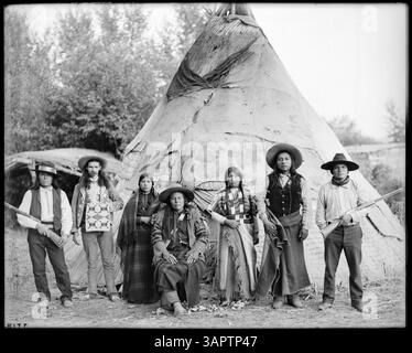 Une photographie de Lee Moorhouse, qui fait partie de la collection des bibliothèques de l'Université de l'Oregon, montrant Arizona Bill avec des Amérindiens à l'extérieur d'un tipi. Banque D'Images