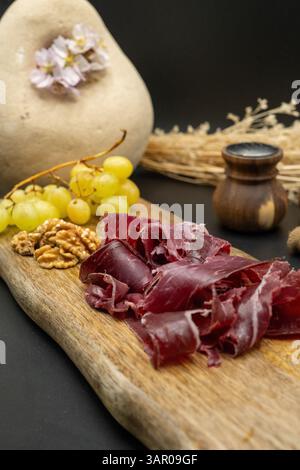 Une planche de charcuterie avec de délicieux raisins et un assortiment de noix, idéale pour les rassemblements Banque D'Images