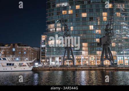 Vue nocturne du bâtiment moderne en verre et des grues près du front de mer de Londres Banque D'Images