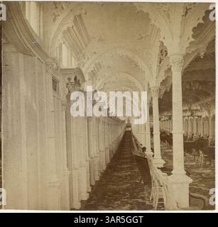 Une photographie stéréographique en noir et blanc représente une allée dans la cabine du bateau à vapeur *Grand Republic*. L'image montre des colonnes, des chaises disposées vers la droite et un mur à gauche, offrant une vue détaillée de l'intérieur d'un bateau à vapeur du XIXe siècle. Banque D'Images