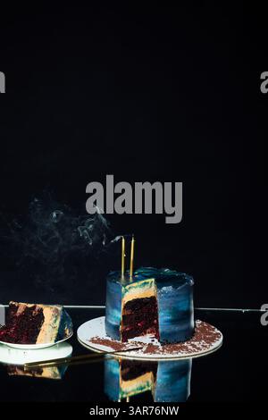 Gâteau d'anniversaire avec deux bougies sur un fond noir Banque D'Images