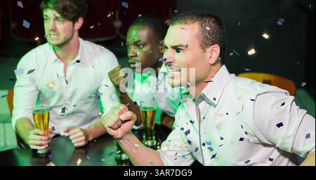 Image de confettis tombant sur un groupe diversifié heureux d'amis buvant dans le bar Banque D'Images