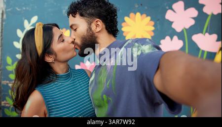 Baiser, mur et selfie de couple avec peinture pour art, décoration ou projet créatif. Amour, liaison et photo POV d'homme ou de femme avec murale pour Banque D'Images