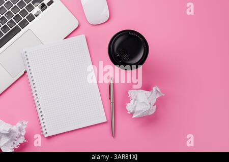Vue de dessus d'un bureau rose avec fournitures de bureau, tasse à café et bloc-notes vierge. Espace de travail féminin et créatif avec espace de copie Banque D'Images