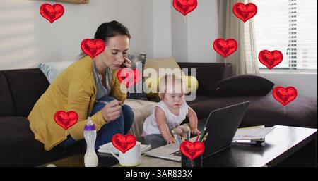 Image d'icônes de coeur sur la mère caucasienne avec bébé parlant sur smartphone Banque D'Images
