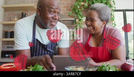 Plusieurs icônes de hamburger contre un couple aîné afro-américain à l'aide d'une tablette numérique dans la cuisine Banque D'Images