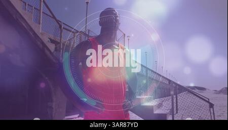 Scanner rond et des taches lumineuses brillantes contre l'homme de forme afro-américain debout à la plage Banque D'Images